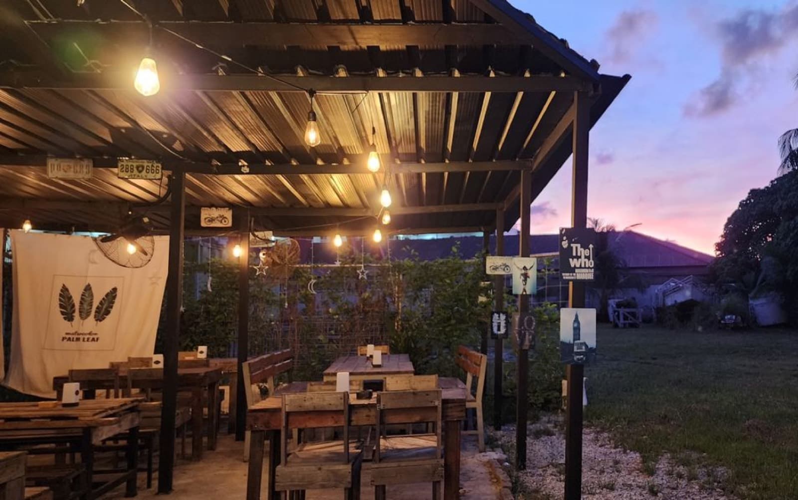 Brian's Bar patio at dusk — string lights over timber tables